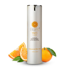 A bottle of BioPo Vital C Cream with orange-colored skin care product and slices of orange with leaves on the side.